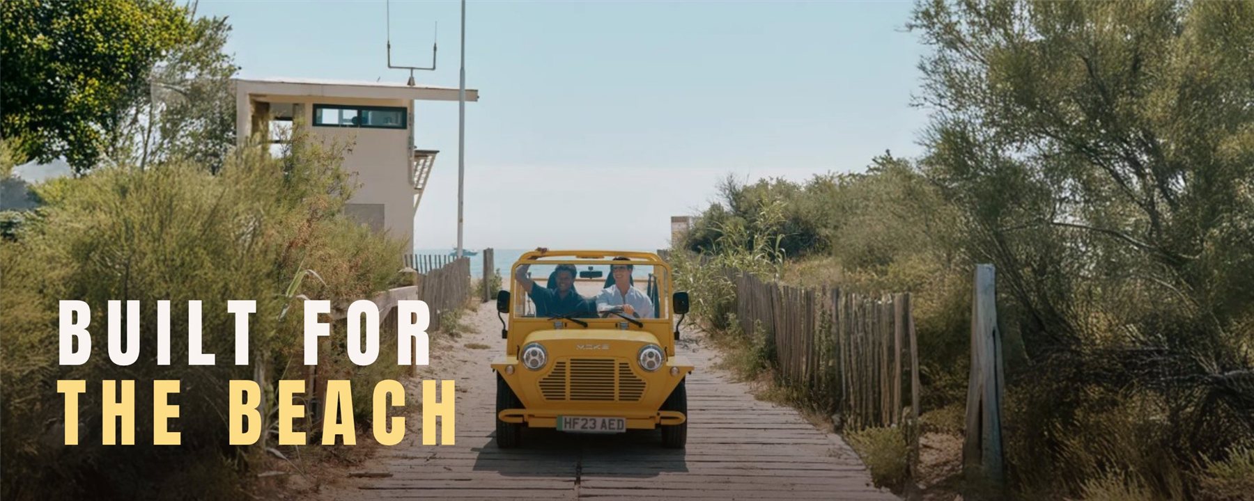 Moke — mood: žuti Moke na drvenoj stazi ka plaži, natpis Built for the Beach